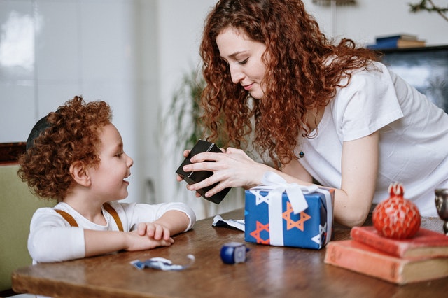 Mother showing a young child a toy